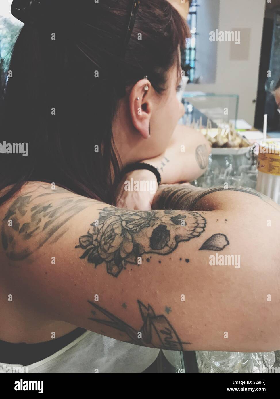 Tattoed jeune femme en attente d'un verre au bar Banque D'Images