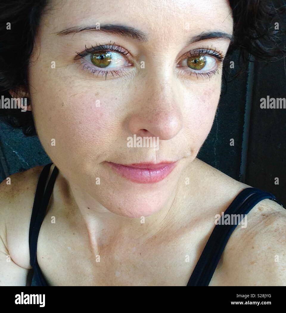 Femme avec des yeux noisettes et des cheveux bruns foncés portant du rouge à lèvres Rose - Image de stock capturée avec un smartphone