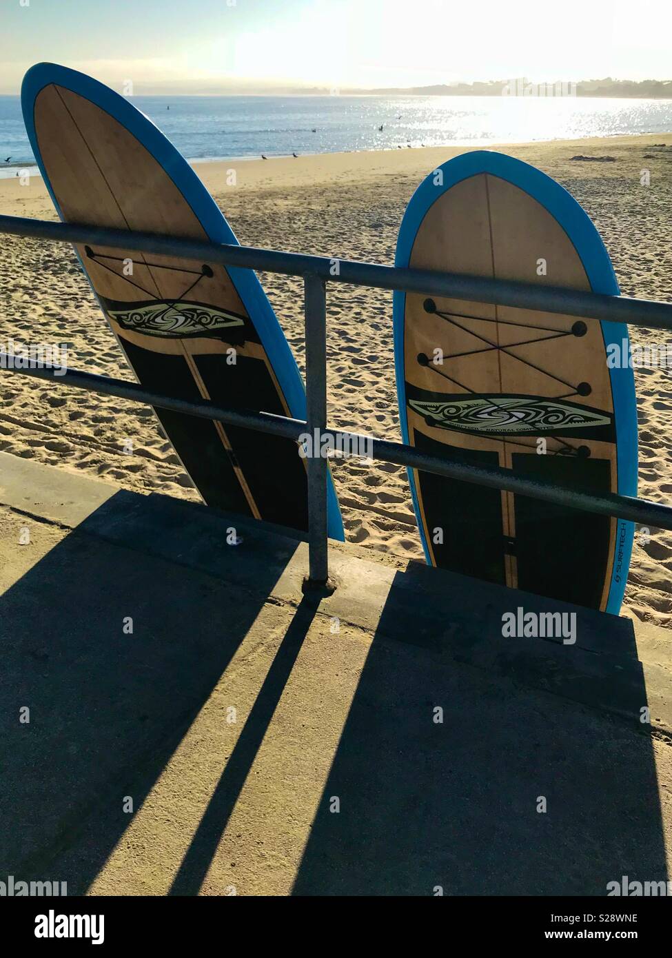 Deux planches de leaning on clôture métallique par beach - Image de stock capturée avec un smartphone