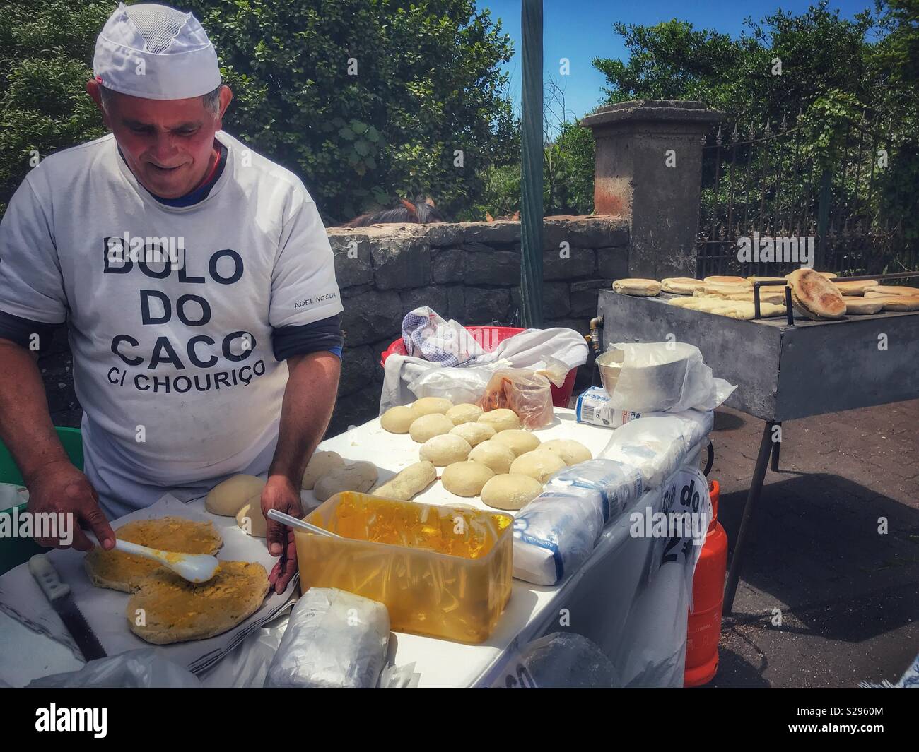 L'homme la fabrication et la vente de produits frais Bolo do Caco au bord de la route dans la région de Santo da Serra, Machico, Madère Banque D'Images