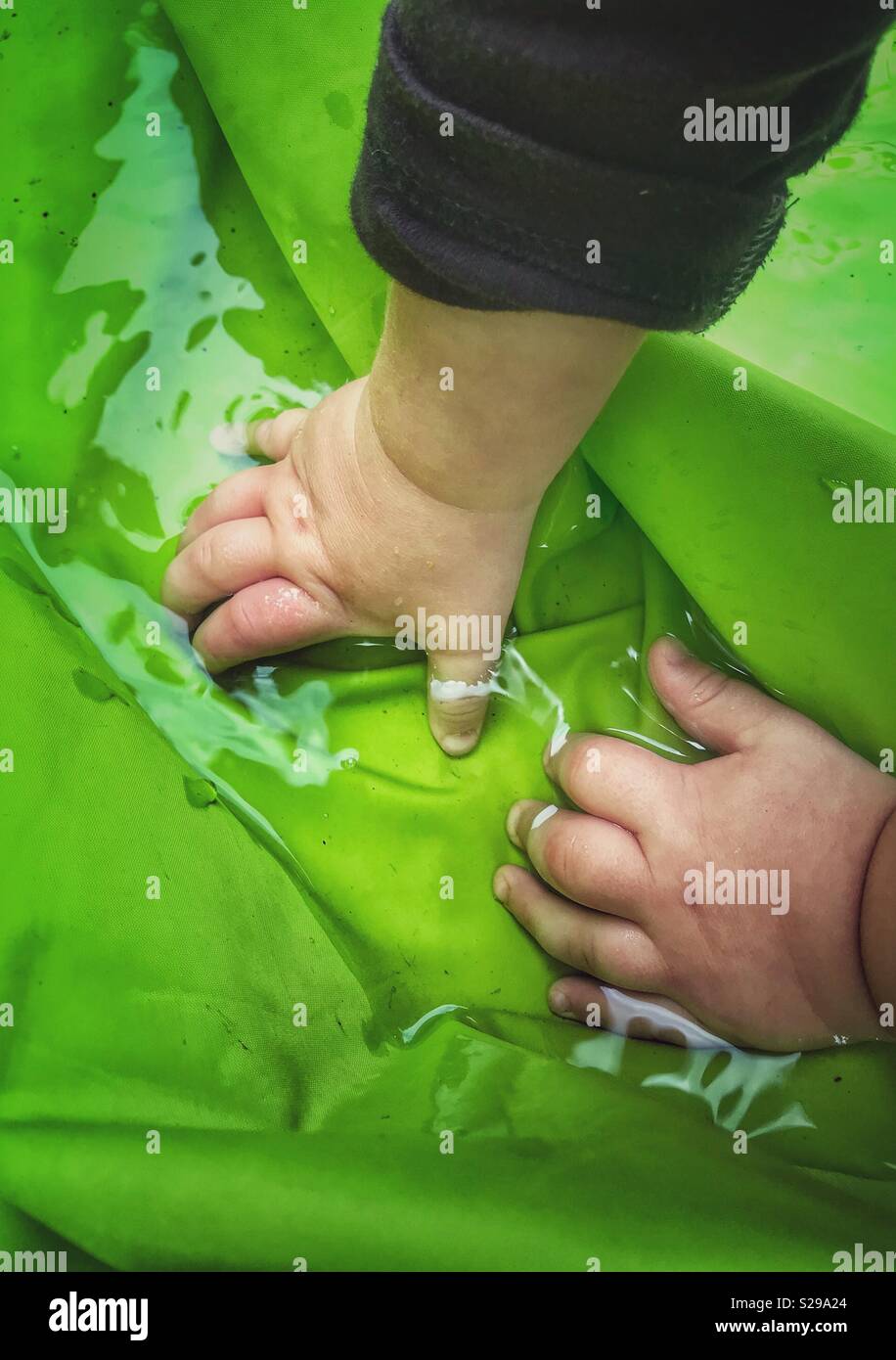 Les mains des bébés dans l'eau Banque D'Images