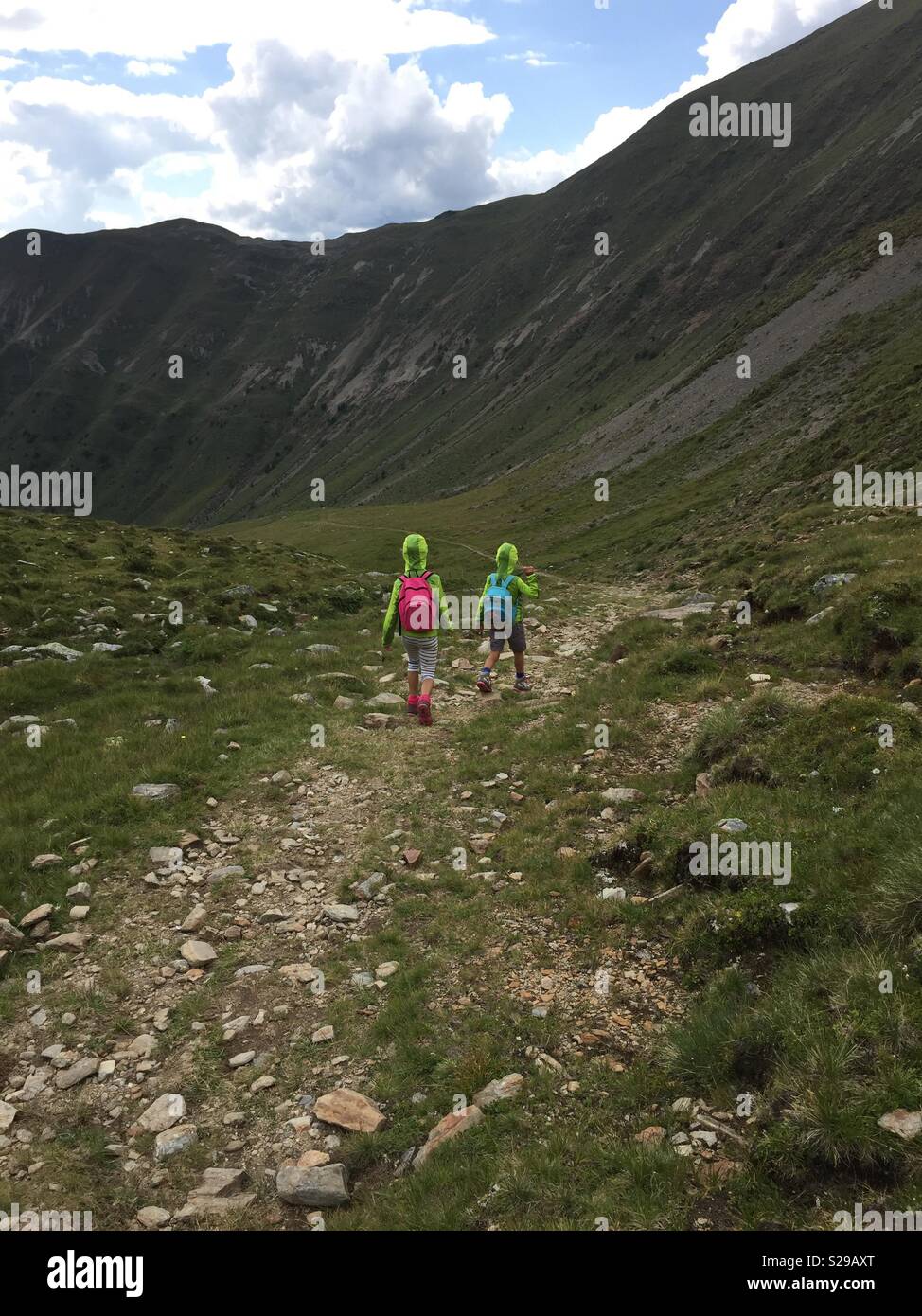 Les enfants de marcher en descente sur un sentier de montagne. Banque D'Images