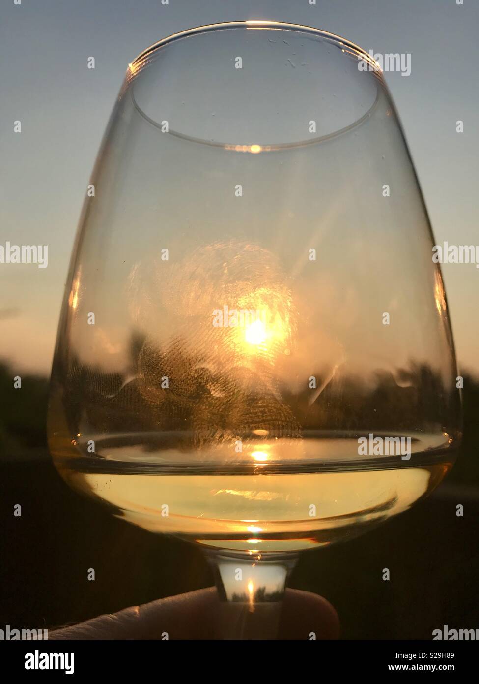 Un verre de vin en plein air dans le soleil couchant Banque D'Images