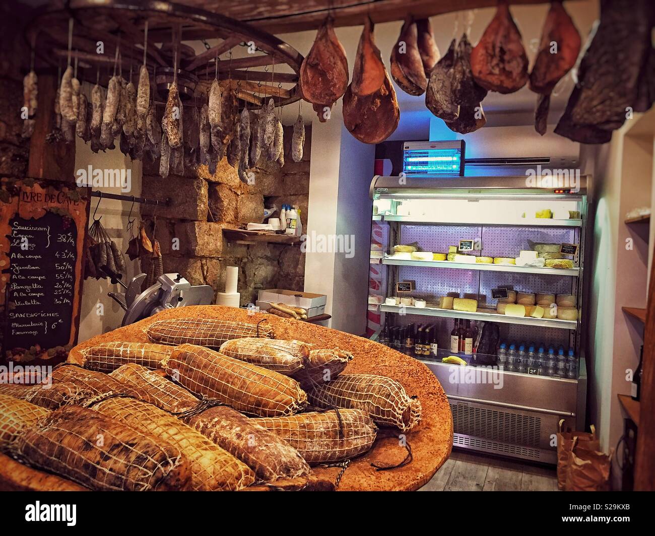 L'intérieur d'une charcuterie Méditerranéenne traditionnelle vente de jambons secs, saucisses et fromages. Banque D'Images