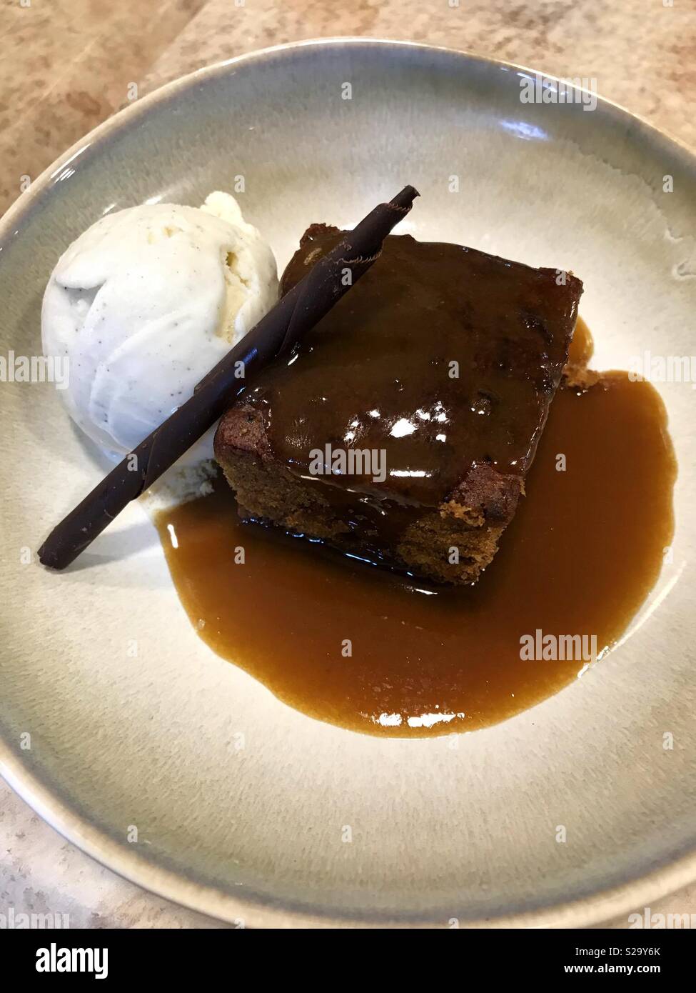 Bol de au caramel, glace vanille et sauce Banque D'Images