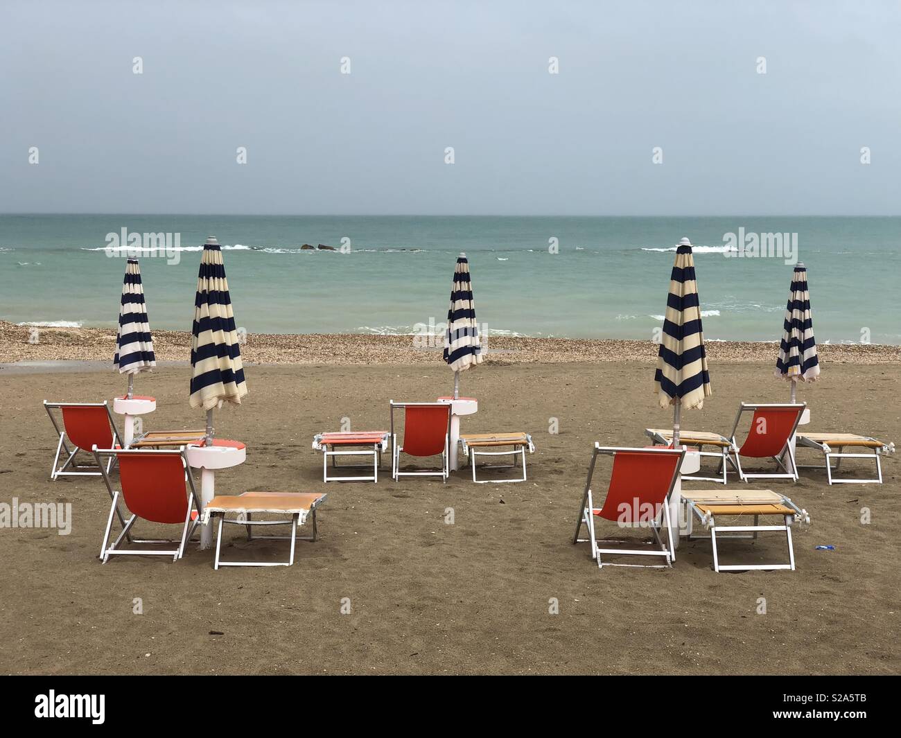 24 septembre pluvieux sur fermé parasols et chaises longues sur la plage Banque D'Images