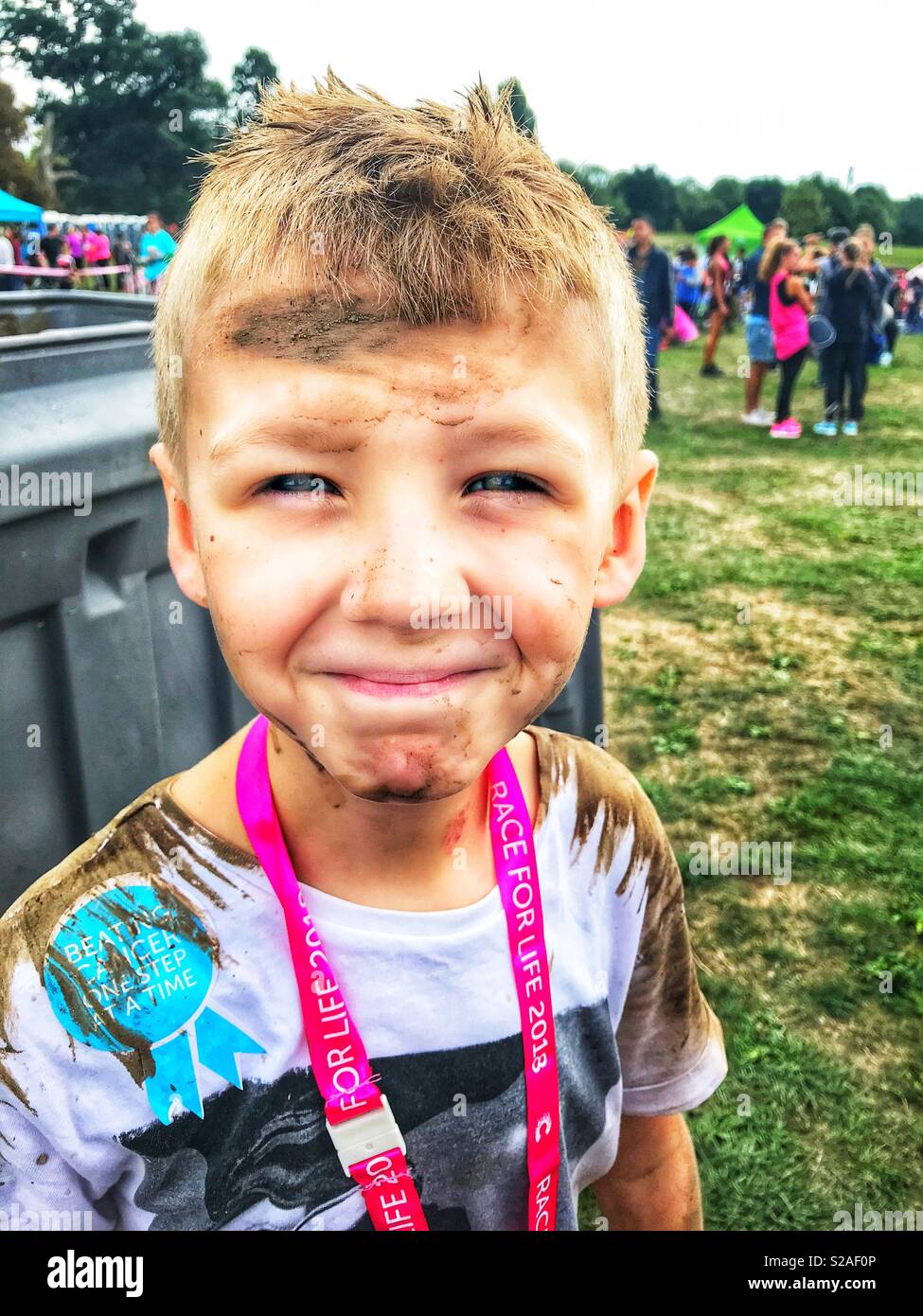 Après un garçon très boueux MUD RUN FOR CANCER RESEARCH Banque D'Images