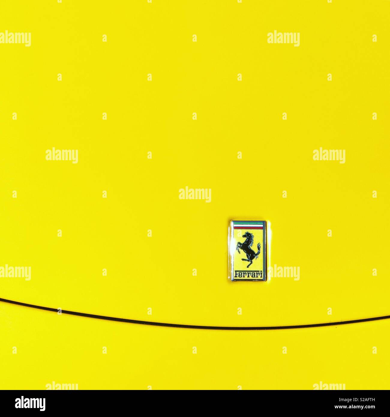 Ferrari voiture de sport italienne emblème sur voiture jaune frais généraux bonet - Image de stock capturée avec un smartphone