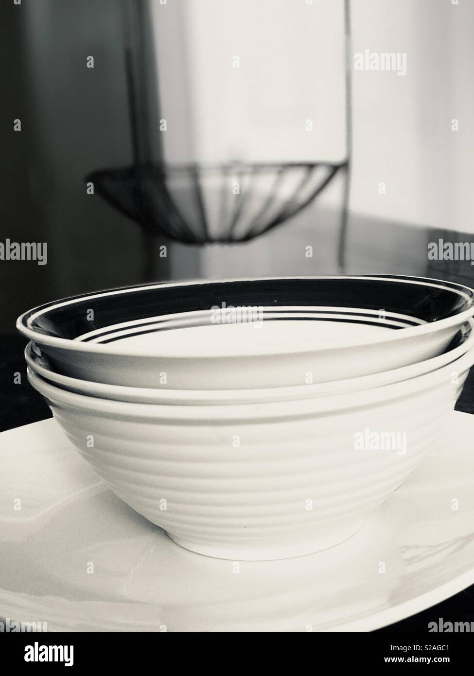 Blanc et noir plats chic empilés sur le comptoir de la cuisine top - panier en fer forgé en toile Banque D'Images