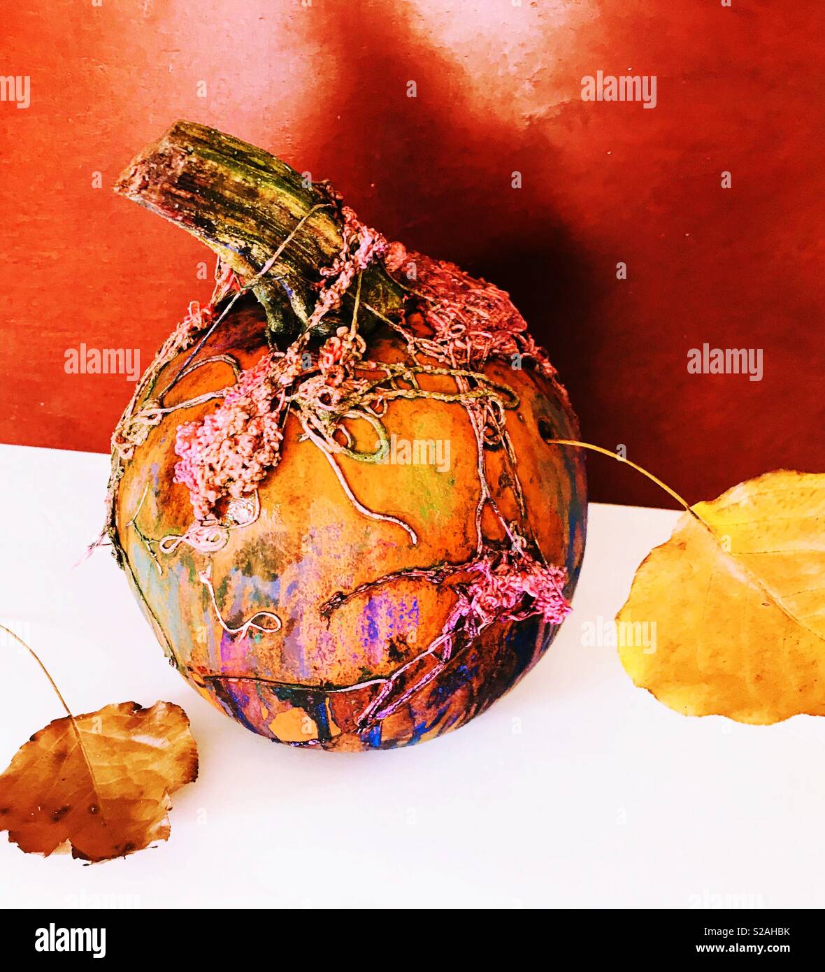 Citrouille de couleur vive avec silly string et feuilles d'automne qui représente le début de l'automne Banque D'Images