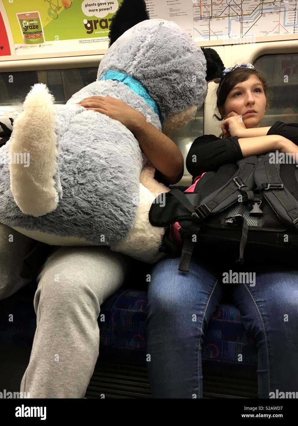 Grand doudou chien assis sur le mans tour en ligne jubilee du métro de Londres Waterloo à côté de woman holding bag Banque D'Images