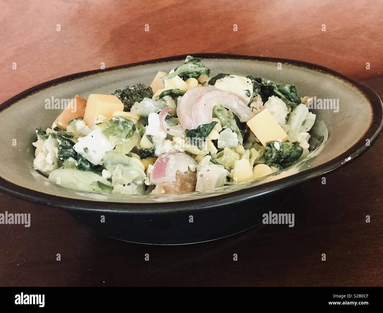 Yummy Salade césar avec légumes mixtes, croûtons, fromage et la vinaigrette dans un bol Banque D'Images