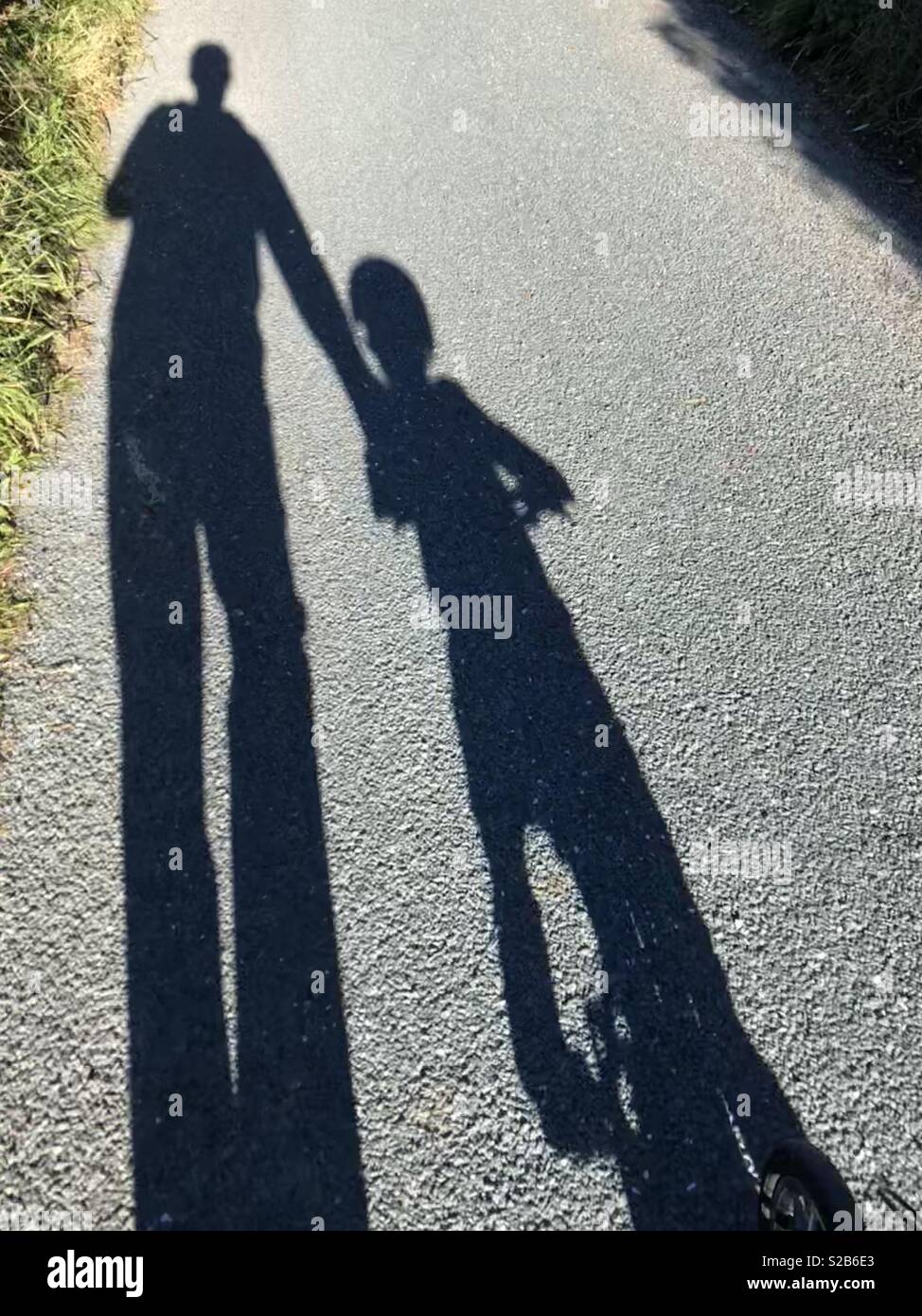 Ombre de père de l'enfant l'enseignement à faire du vélo Banque D'Images