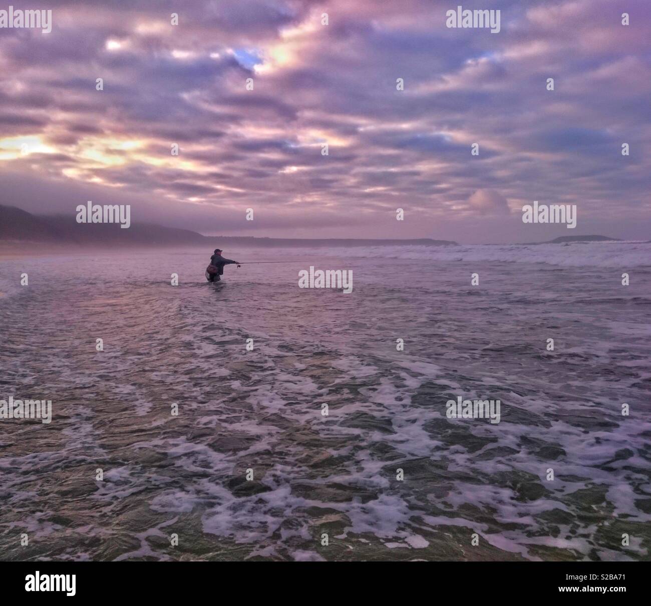 La pêche des pêcheurs pour la basse dans le surf à Llangennith, Gower, le Pays de Galles. Banque D'Images