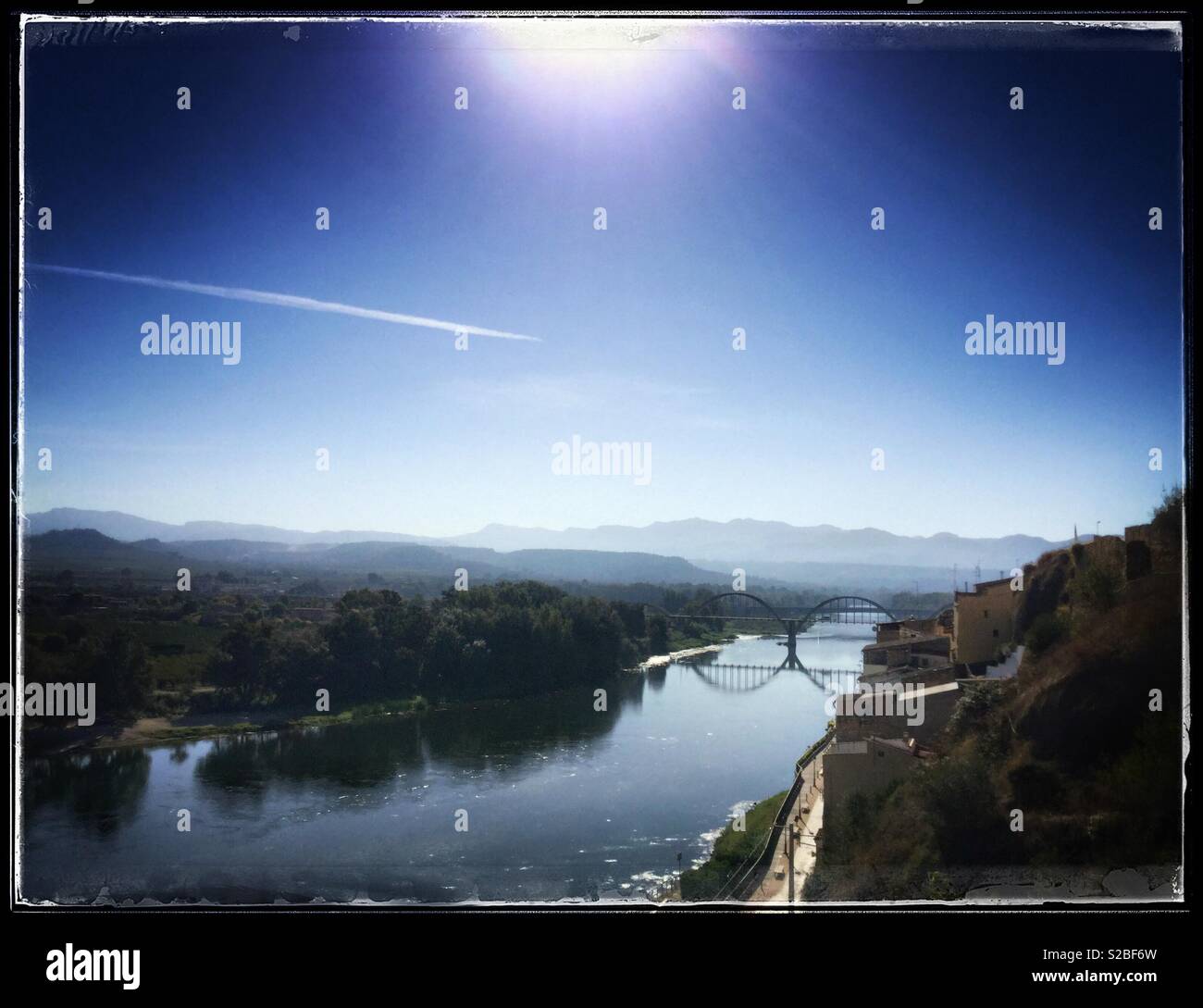 Vue sur le fleuve vers le pont voûté, Mora d'Ebre, en Catalogne, Espagne. Banque D'Images