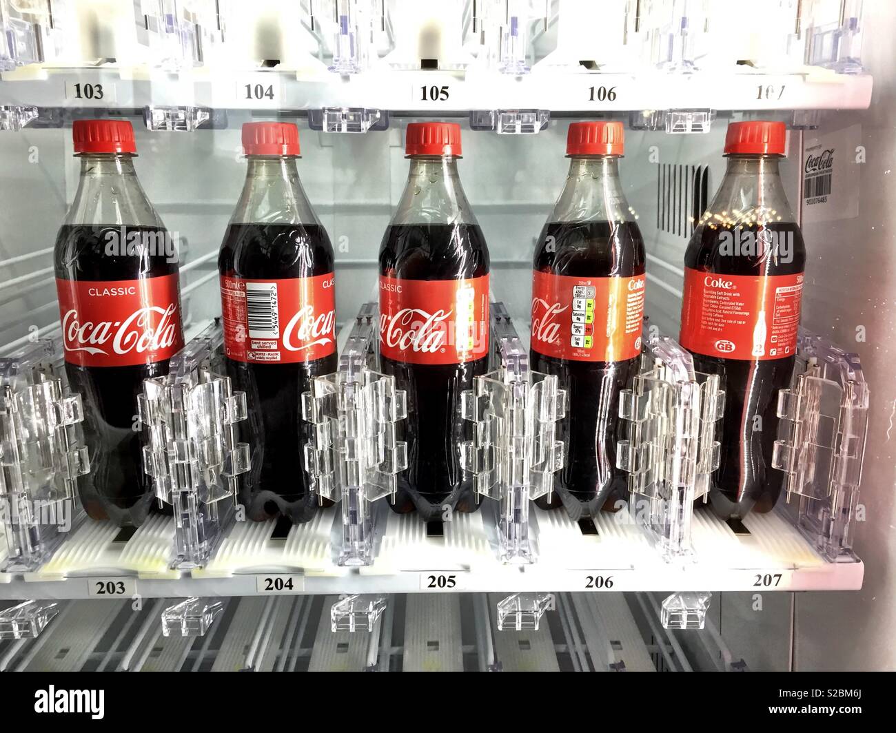 Bouteille de coke dans un distributeur automatique. Banque D'Images