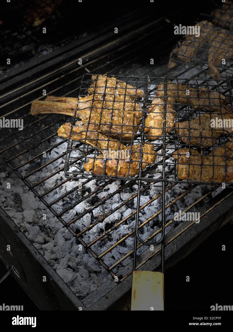 Les côtelettes d'agneau mariné aux épices sur un barbecue au charbon de bois chaud Banque D'Images