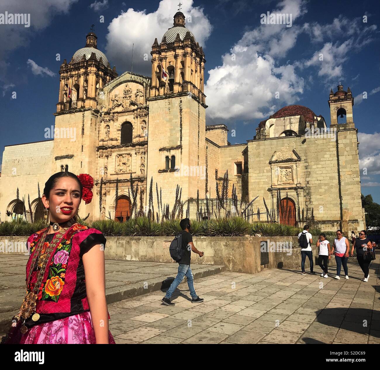 Une femme vêtue comme une 'tehuana' se trouve en face de l'église de Santo Domingo à Oaxaca, Mexique Banque D'Images