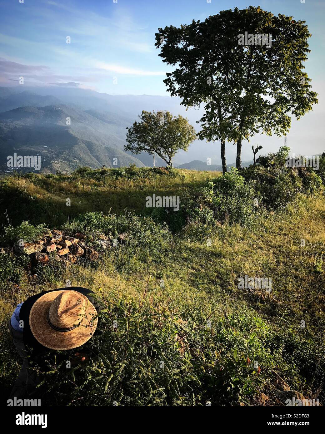 Les touristes d'un guide vêtu d'une paille se tient dans le Cerro del Jaguar hill dans Lachatao, dans la Sierra Norte de Oaxaca, Mexique Banque D'Images