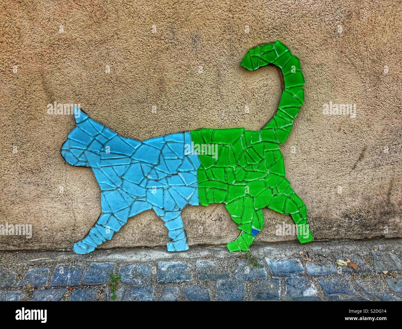 Un chat en mosaïque bleu et vert sur un mur. Banque D'Images