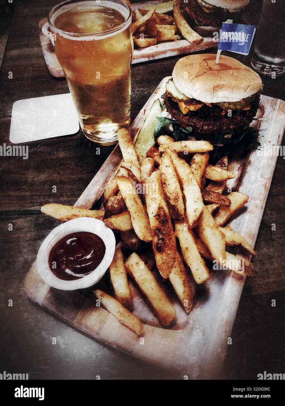 Célèbre impossible vegan burger avec des frites et du cidre Banque D'Images
