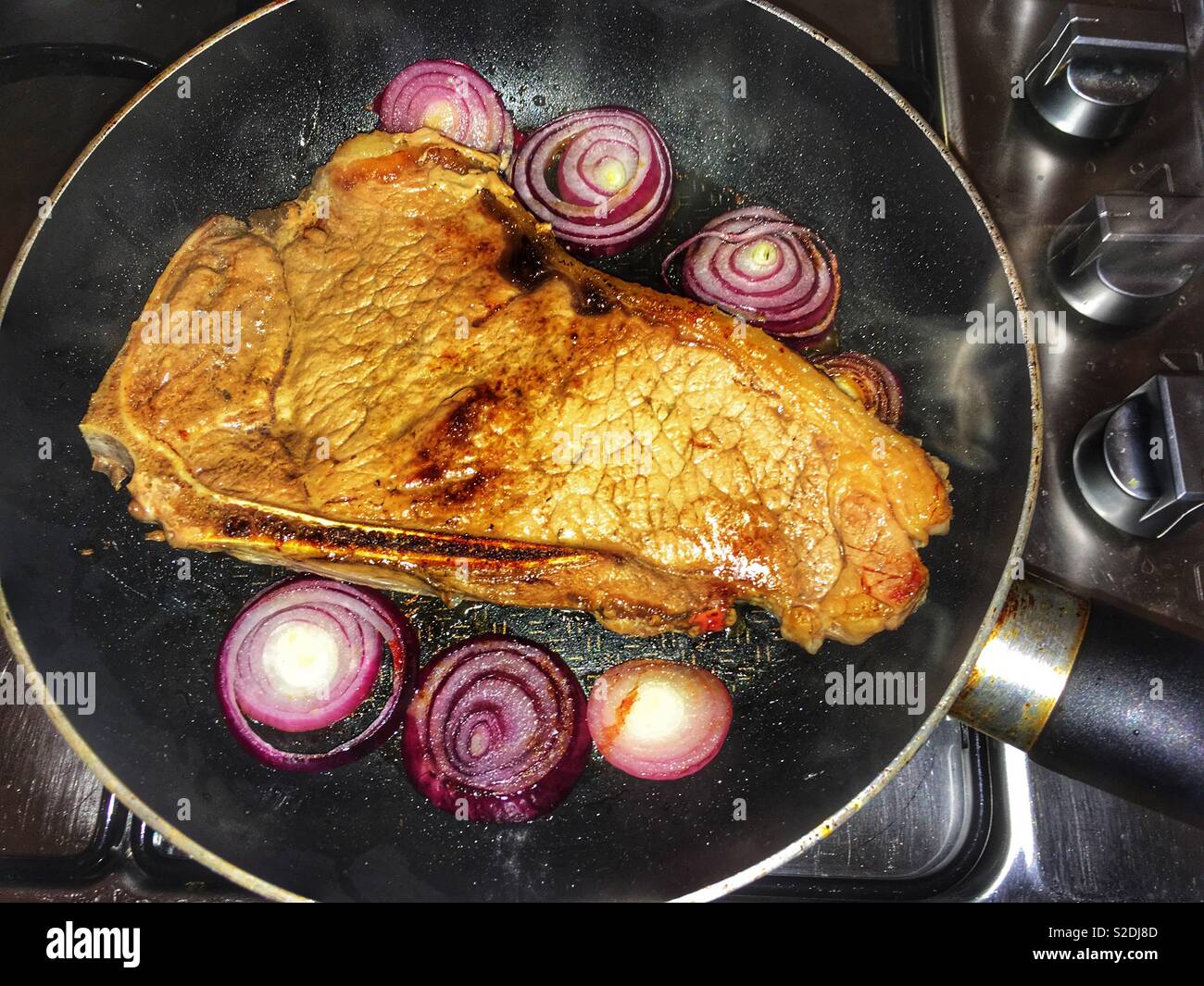 La viande bovine britannique Waitrose désossée de bifteck poêlé aux oignons rouges - Image de stock capturée avec un smartphone