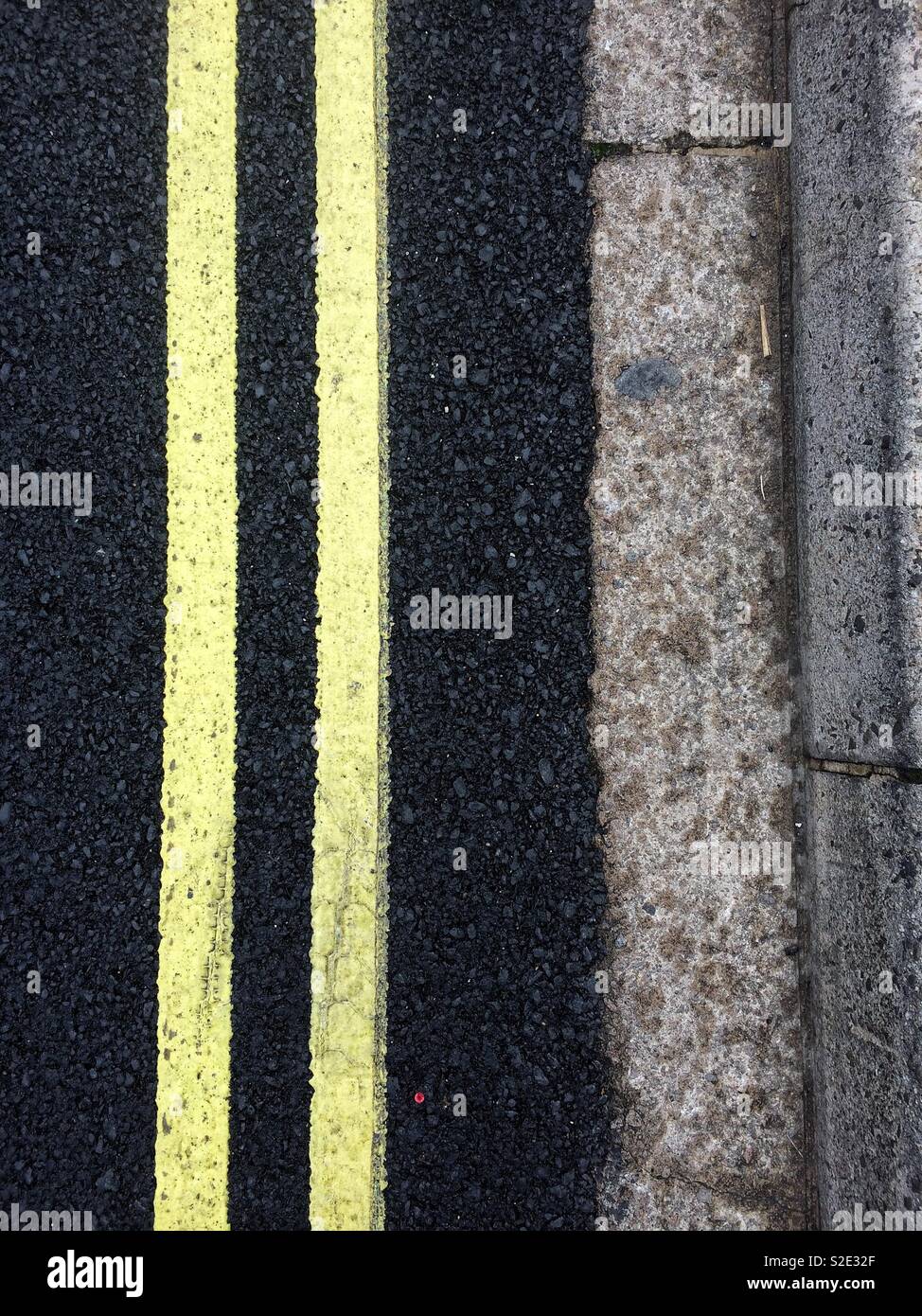 Des lignes jaunes et bordure en béton sur l'asphalte - Image de stock capturée avec un smartphone