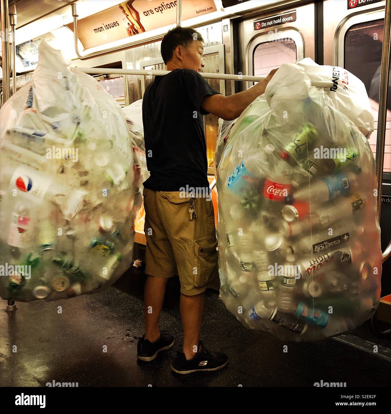 Homme avec collection de bouteilles et boîtes équitation le métro Banque D'Images