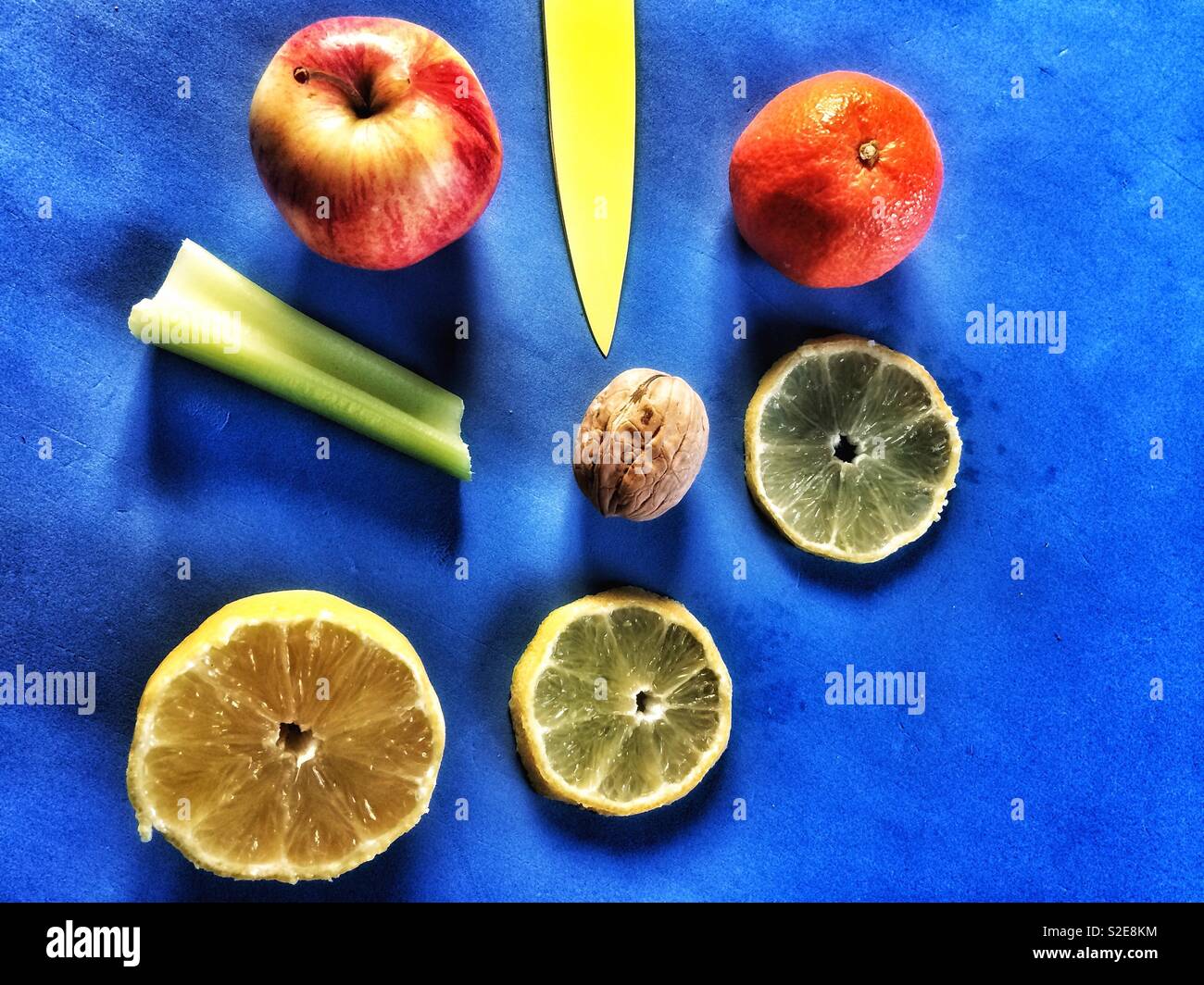 Nature morte de fruits,mandarine,apple,tranches de citron,l'écrou et le couteau jaune pointant. - Image de stock capturée avec un smartphone