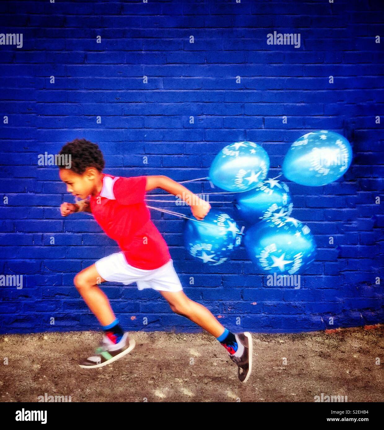 Petit garçon courir avec des ballons. Banque D'Images