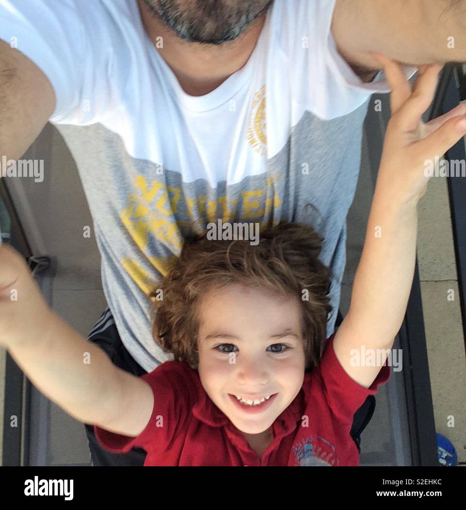 Un garçon de six ans en tenant avec son père selfies Banque D'Images