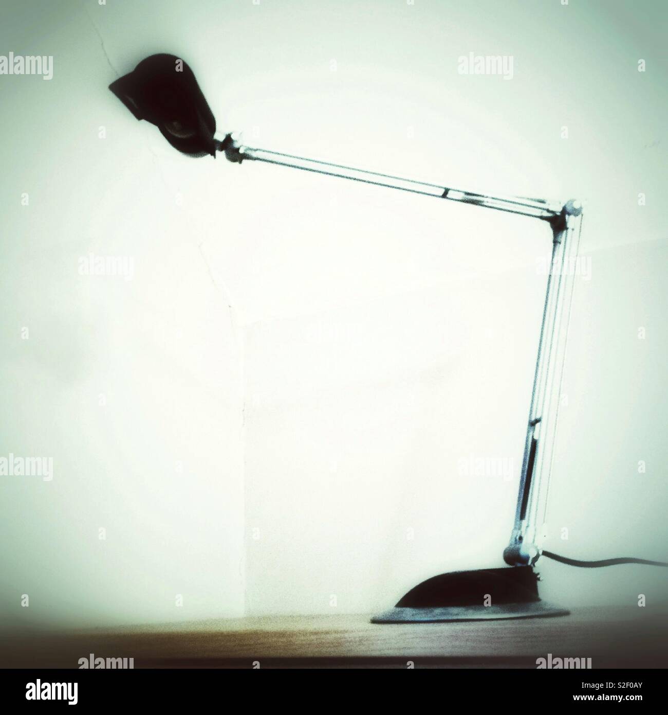 Monochrome, photo minimaliste de l'angle moderne de bureau lampe de bureau style poise sur fond blanc. - Image de stock capturée avec un smartphone