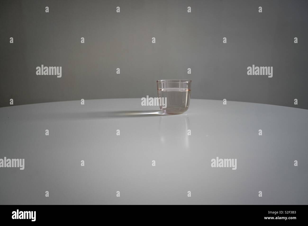 Verre d'eau sur un tableau blanc Banque D'Images