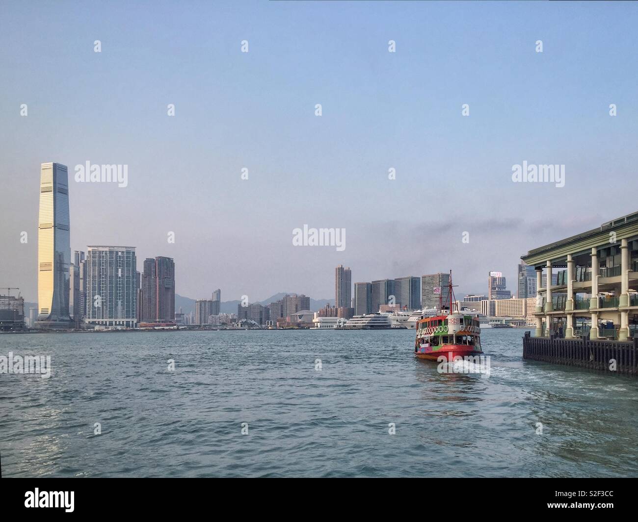 L'emblématique Star ferry, peint dans la livrée de la marque Hong Kong, départ de Central Pier 7 pour traverser le port de Victoria à Tsim Sha Tsui à Kowloon - Image de stock capturée avec un smartphone