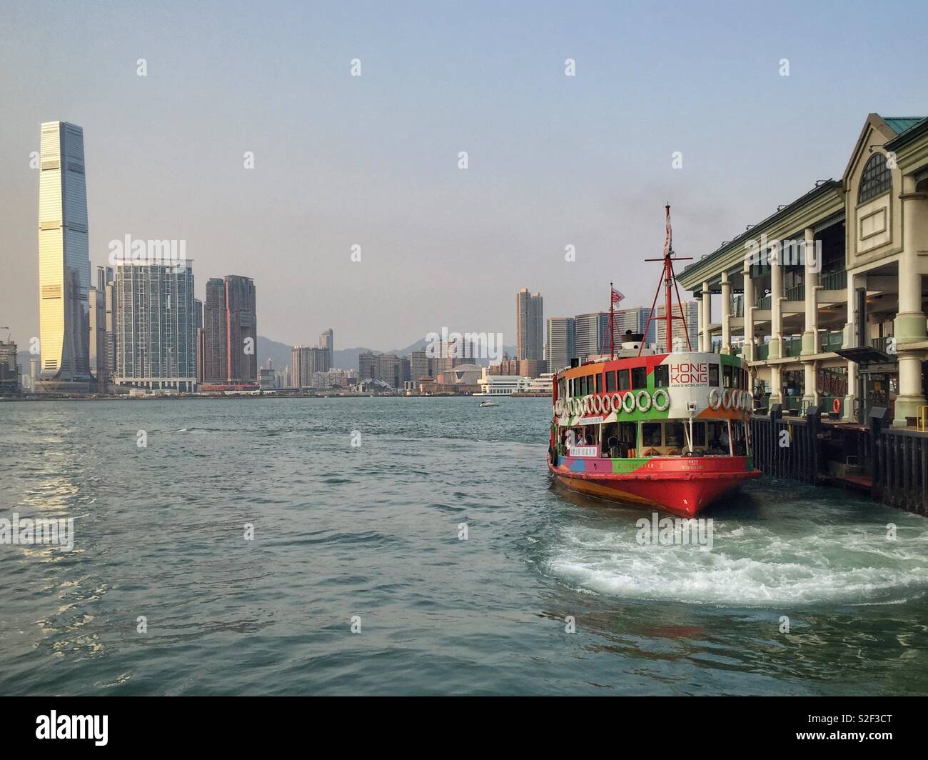 L'emblématique Star ferry, peint dans la livrée de Hong Kong, la marque arrive à Central Pier 7 après avoir traversé le port de Victoria à partir de Tsim Sha Tsui à Kowloon - Image de stock capturée avec un smartphone