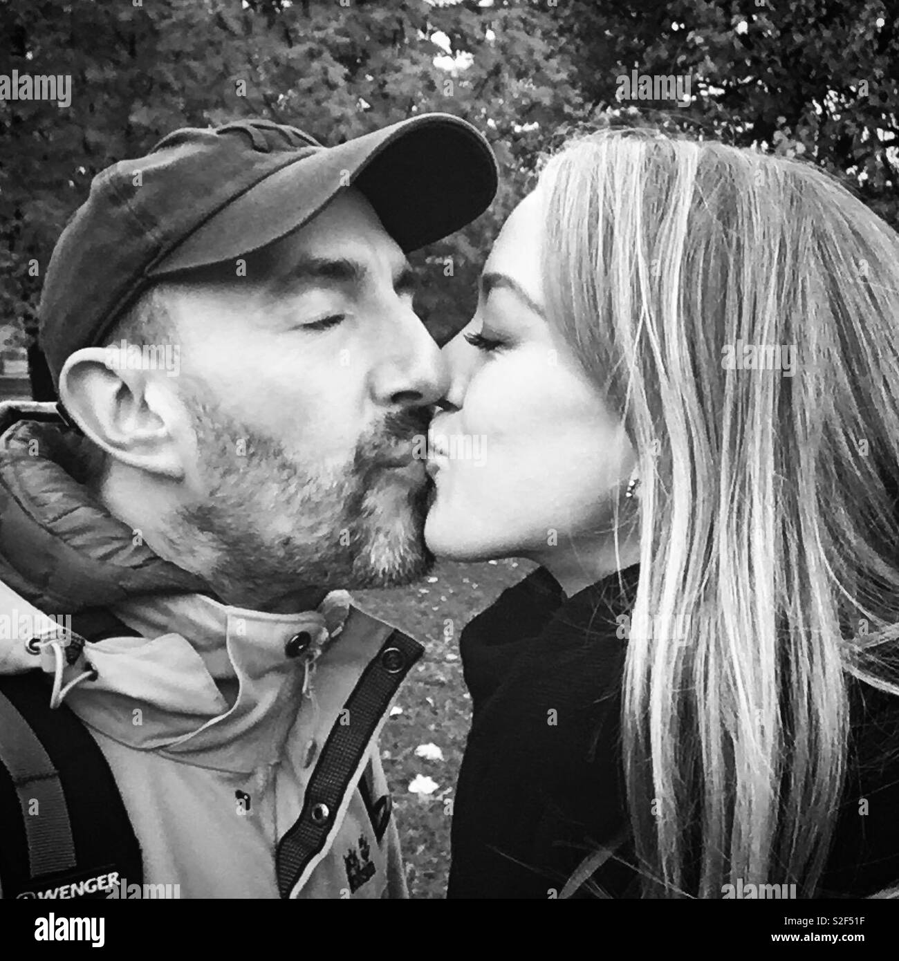 Noir et blanc photo de couple kissing in park. Banque D'Images