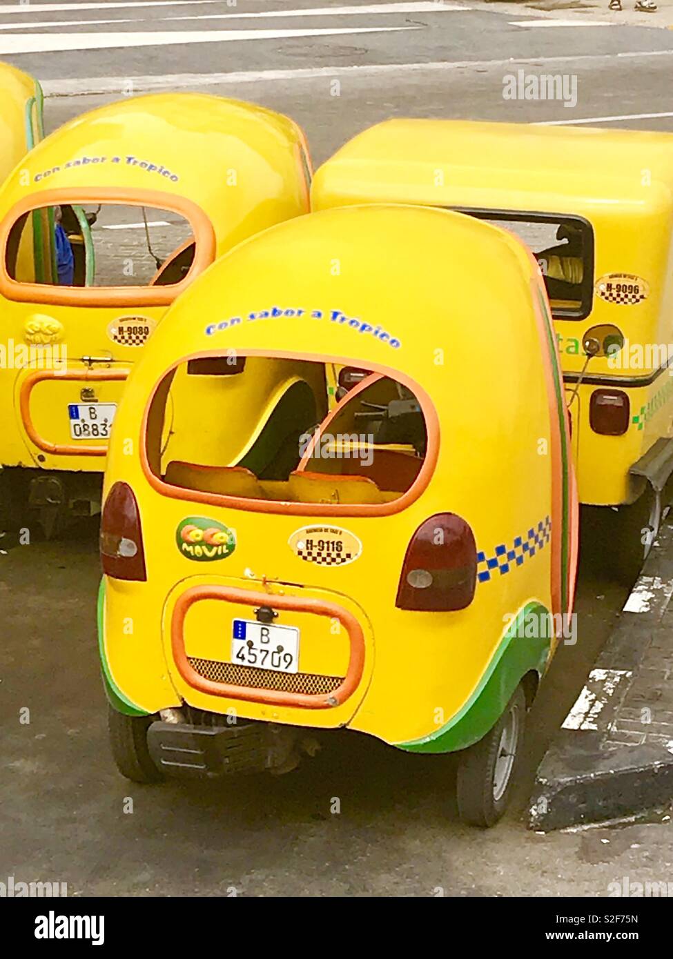 Les petits taxis de couleur jaune vif à prendre des passagers à leur destination dans le centre-ville de La Havane Cuba Banque D'Images