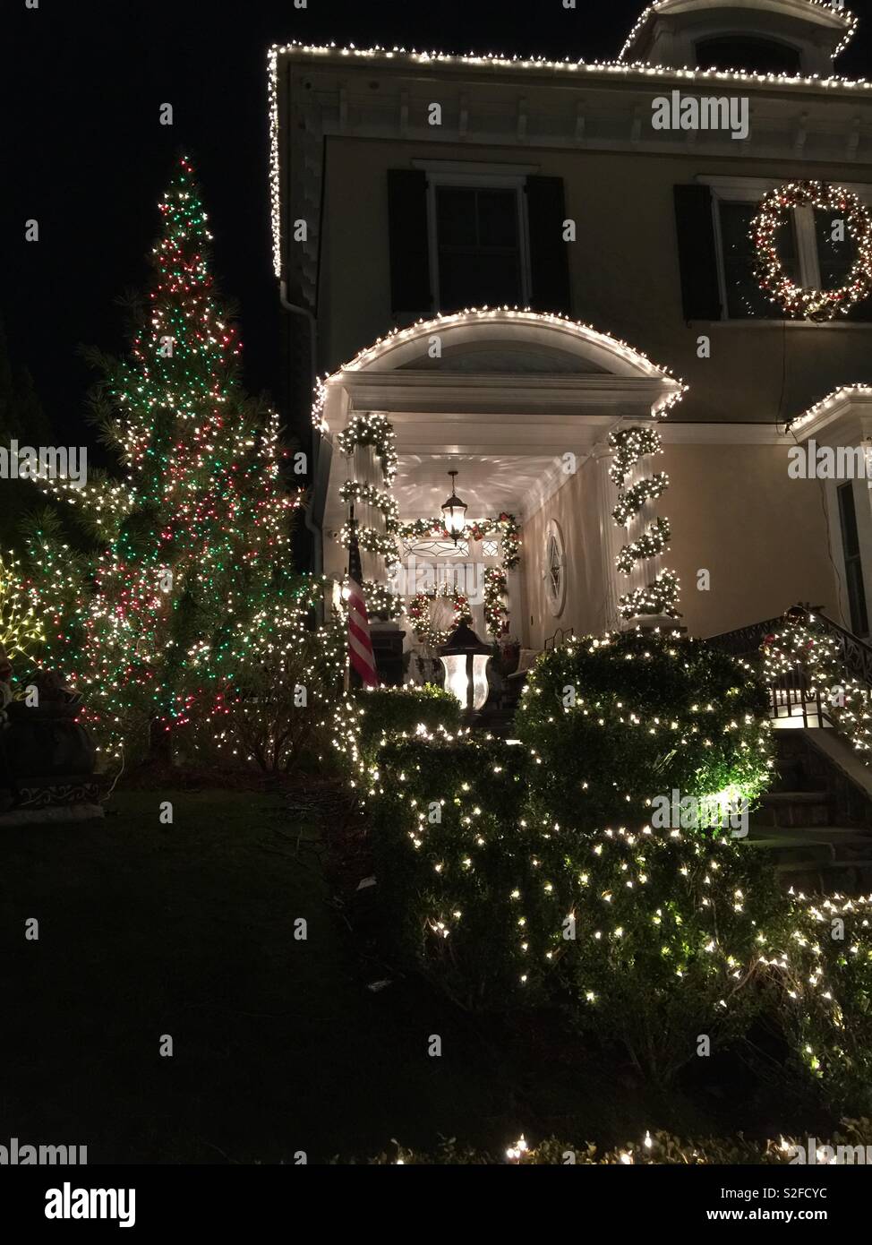 Décorations de Noël et d'éclairage sur une grande maison et arbre Banque D'Images