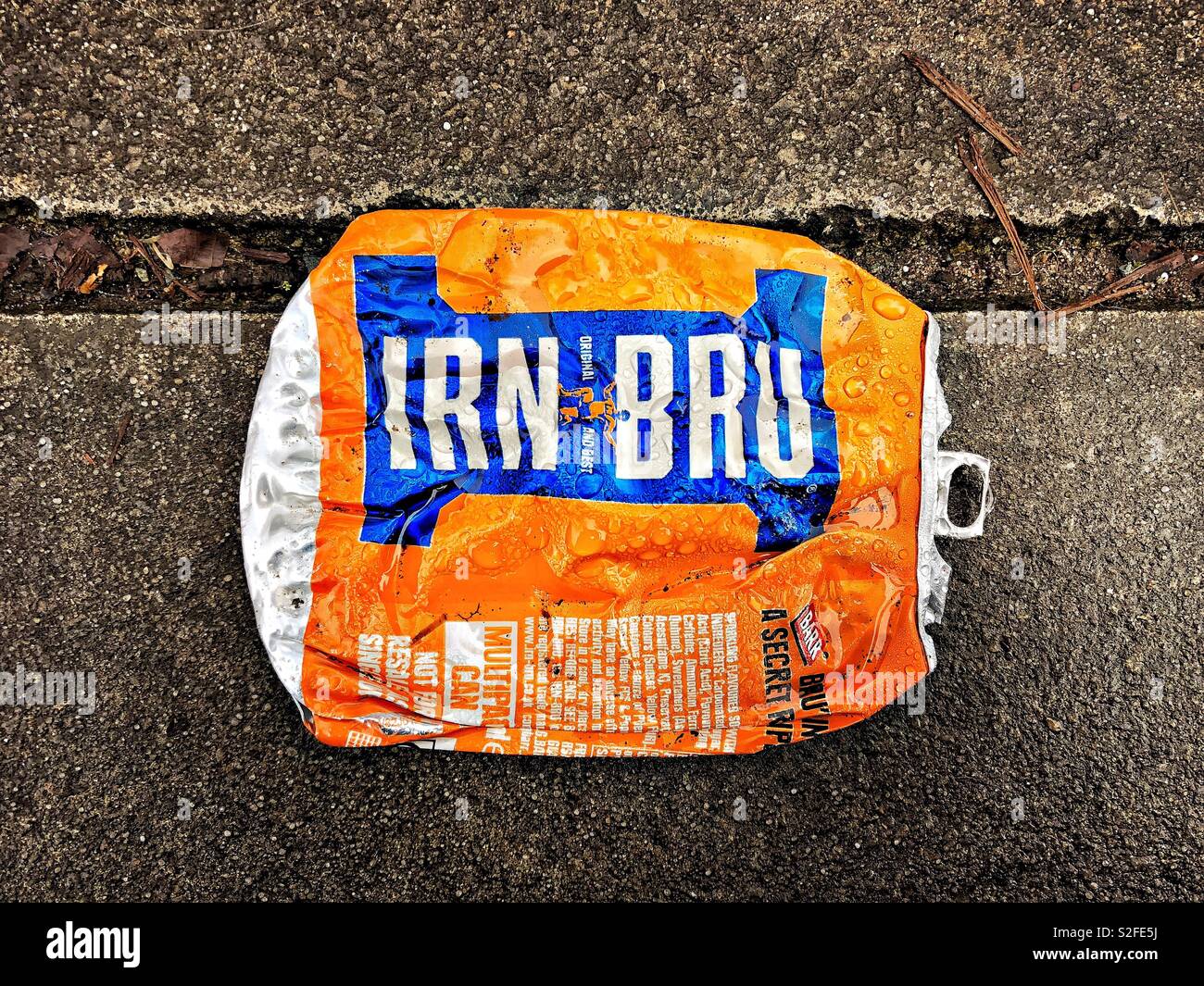 Boîte de boisson Irn Bru aplatie avec le logo visible trouvé dans une rue sur un trottoir en béton à Dumfries, en Écosse. - Image de stock capturée avec un smartphone