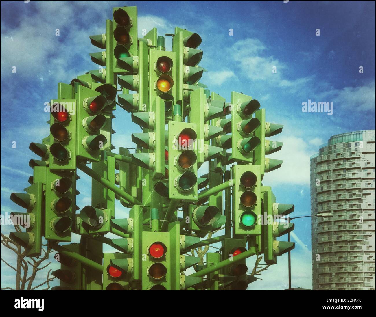 Un effet rétro de l'image "Le feu de circulation Arbre" sur Trafalgar Way, Canary Wharf, Londres, Angleterre. Une sculpture artistique, ne vise pas à contrôler le flux de trafic. Arrêter ou aller ? ? ! © COLIN HOSKINS. - Image de stock capturée avec un smartphone