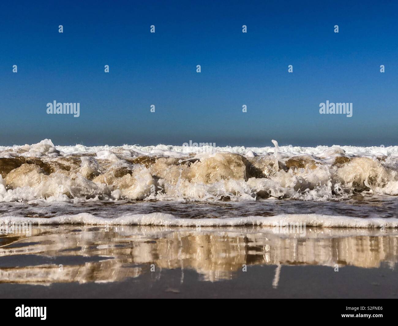 Niveau faible angle de vagues se brisant sur une plage de sable de l'Afrique Maroc - Image de stock capturée avec un smartphone