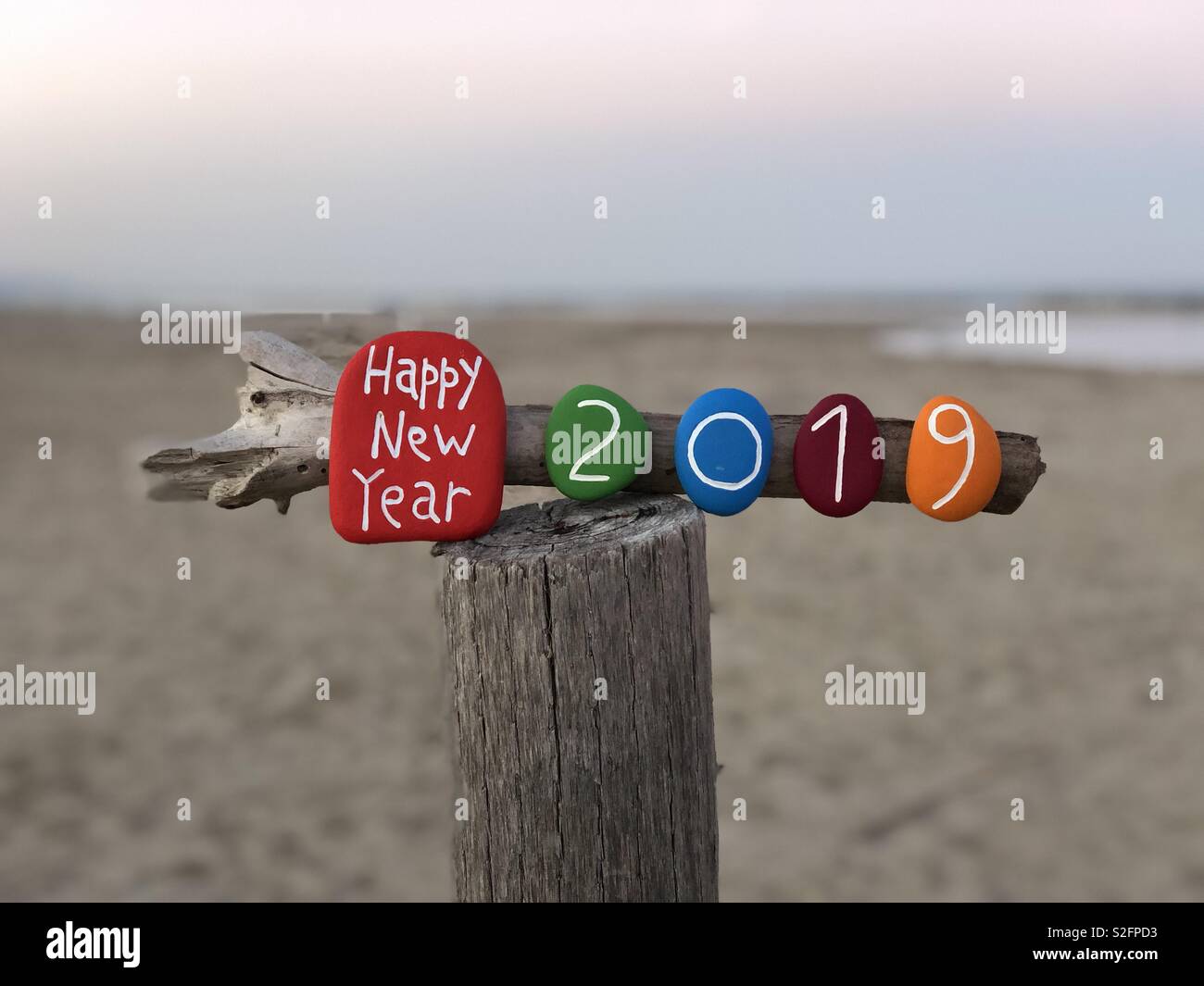 Bonne année 2019 avec une composition de pierres de couleurs sur un poteau en bois Banque D'Images