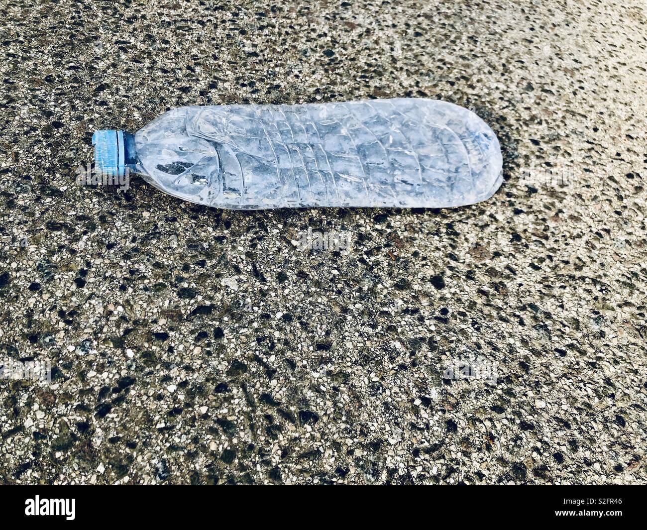 Aplatir la bouteille en plastique vide sur la route - Image de stock capturée avec un smartphone