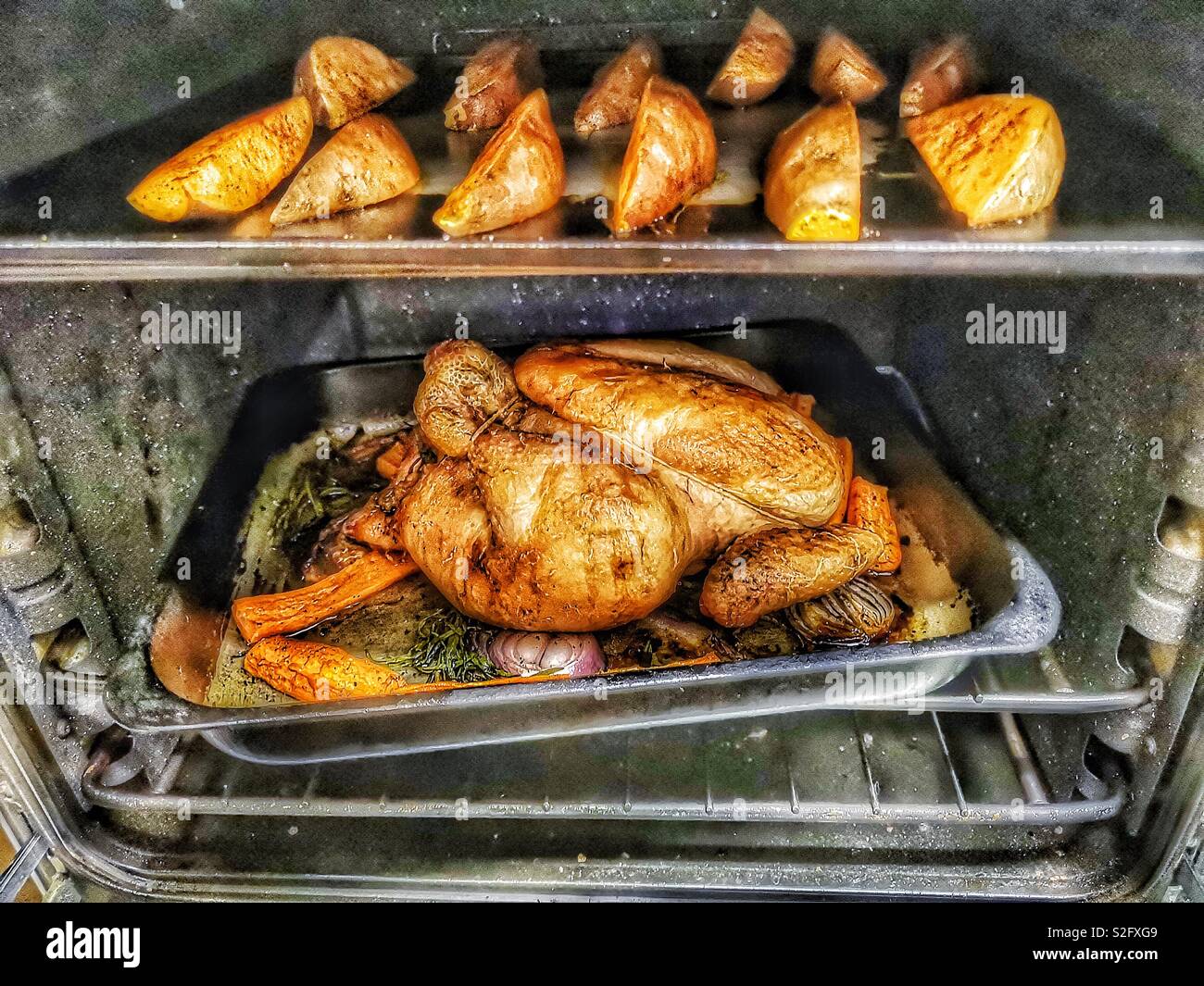 Poulet rôti et pommes de terre au four de cuisson des coins Banque D'Images