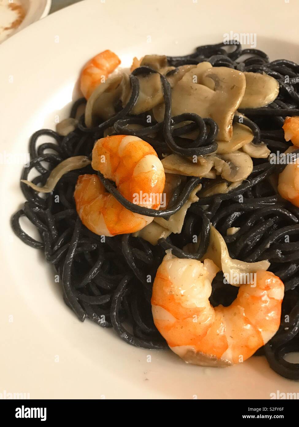 Spaghetti noir avec les crevettes et les champignons. Banque D'Images