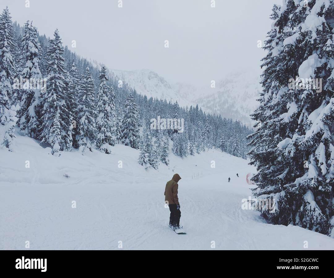 Personne snowboard sur une journée d'hiver enneigée très à la montagne. - Image de stock capturée avec un smartphone