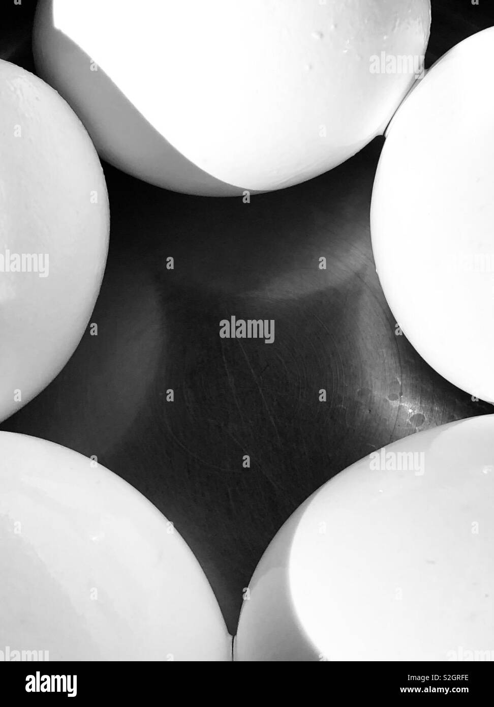 Cinq œufs blancs sur une surface noire de la création d'un résumé Banque D'Images