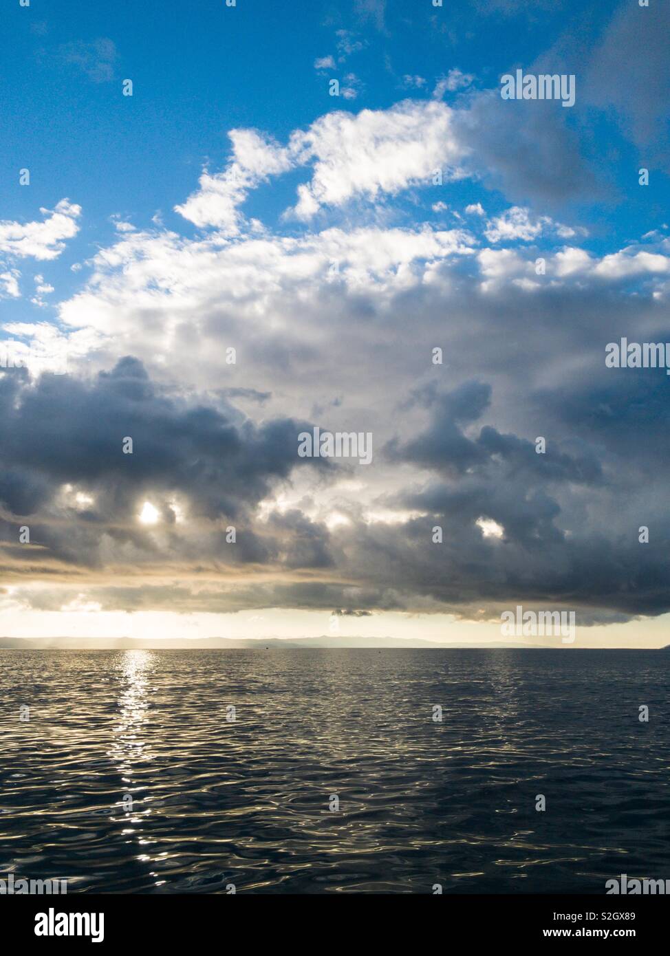 La lumière du soleil à travers les nuages sur la mer Adriatique calme Banque D'Images