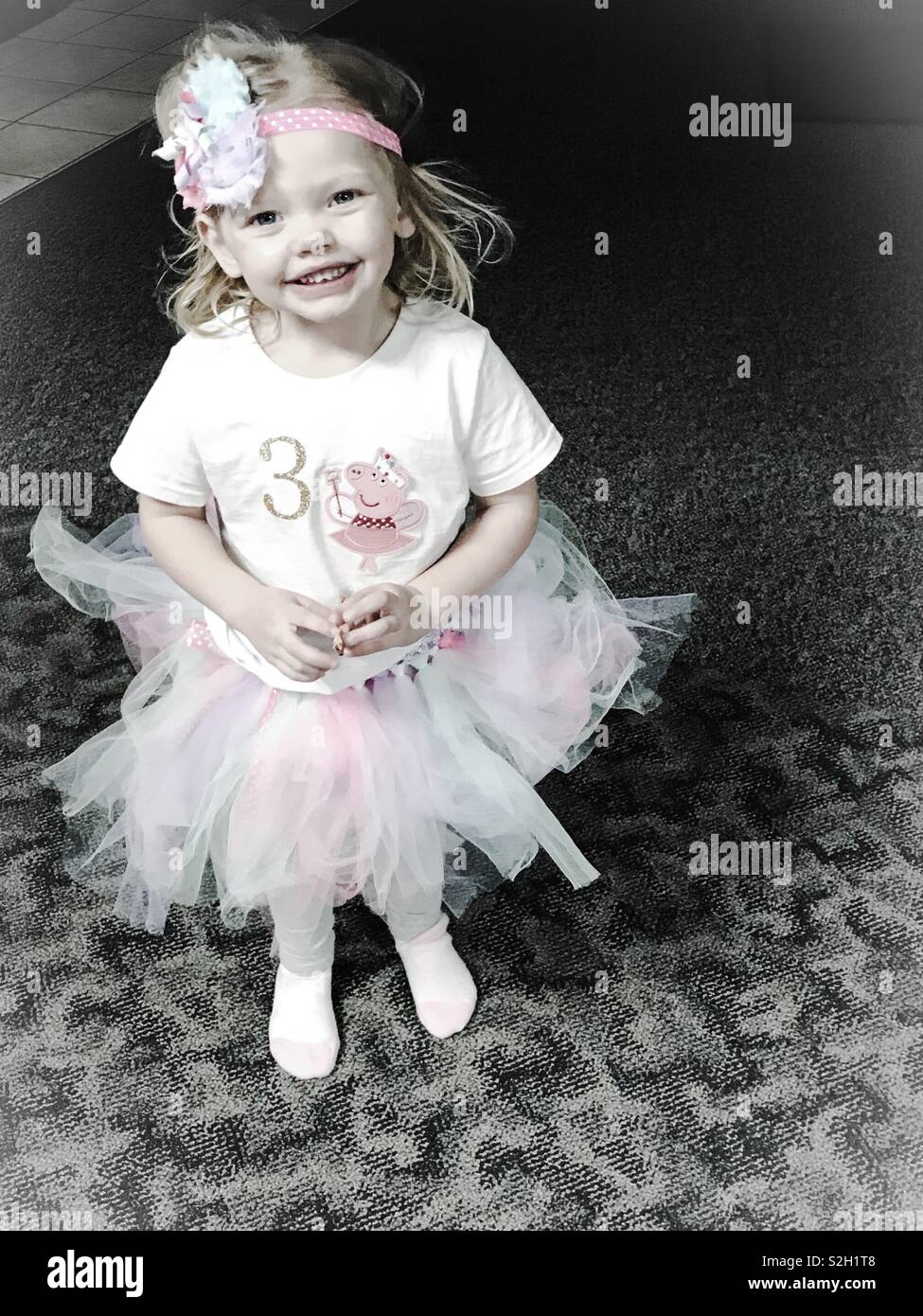 Petite fille portant un bandeau et un Peppa Pig T-shirt avec le numéro 3  sur elle pour son âge à son anniversaire Photo Stock - Alamy