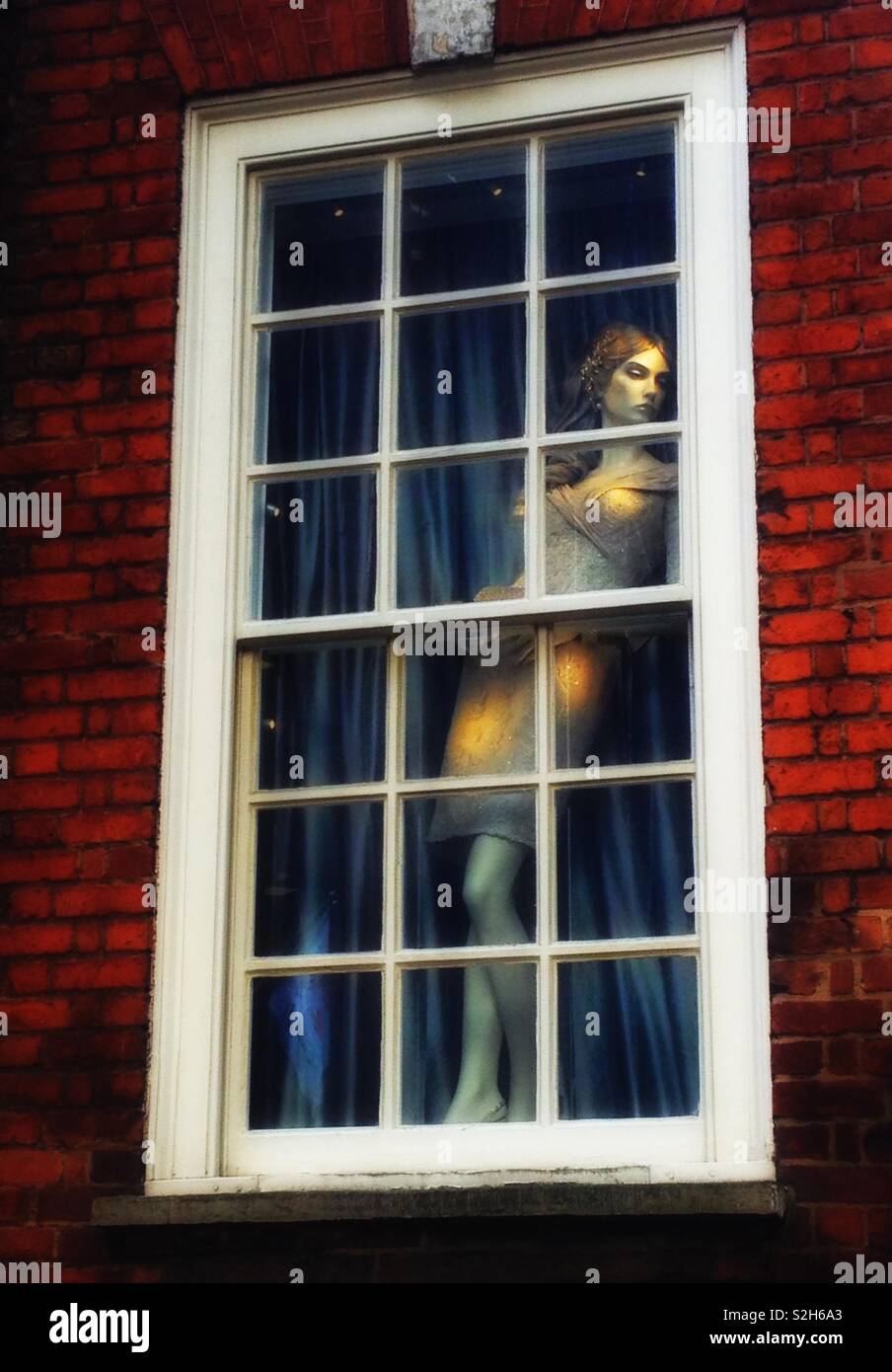 Un mannequin élégant dans la fenêtre d'une suite nuptiale exclusive et robe du soir mise en place à Westminster, Londres, Angleterre Banque D'Images